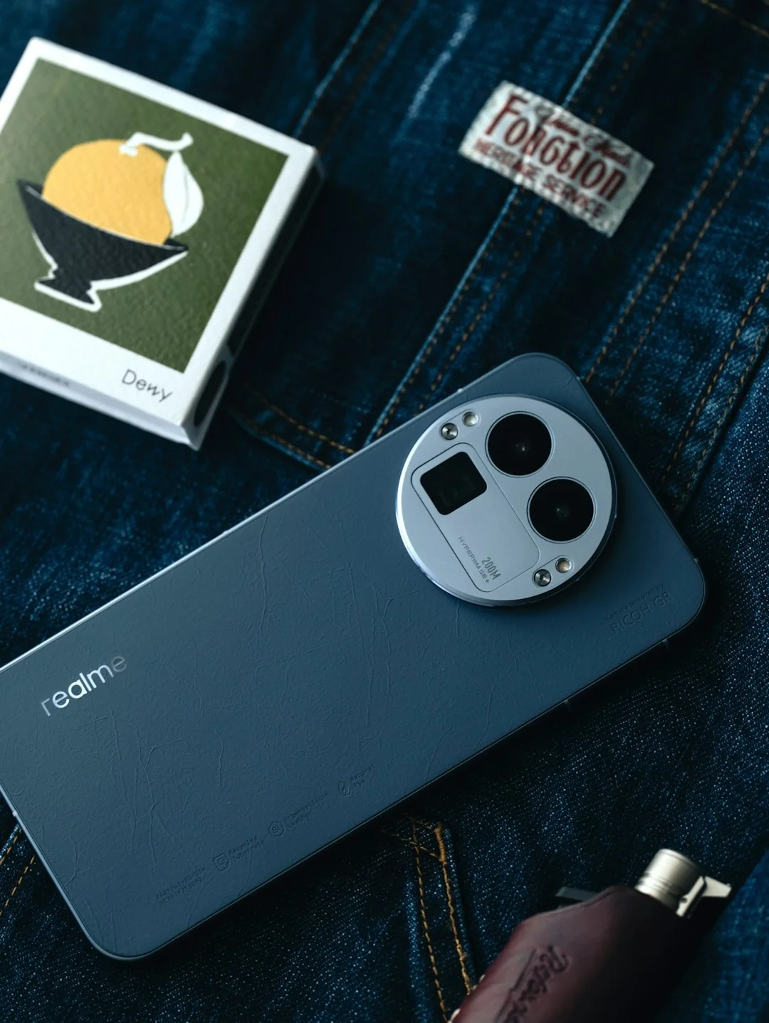 Des mains tapent sur un ordinateur portable tout en tenant un smartphone, illustrant un environnement de travail multitâche.